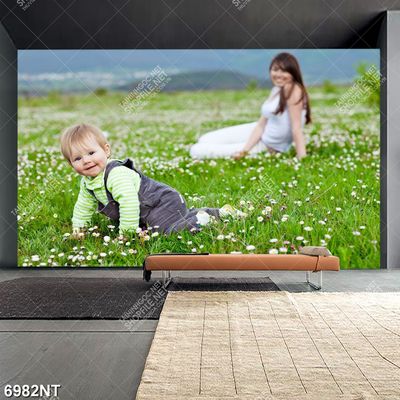 Tranh meẹ và bé ngồi trên thảm cỏ